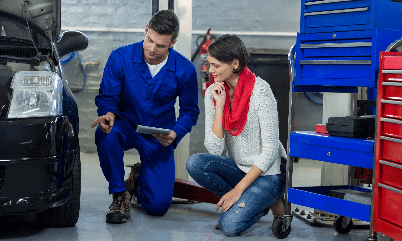mechanic showing customer the problem with car